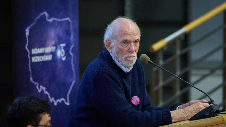 Portrait de Barry Barish installé au pupitre.